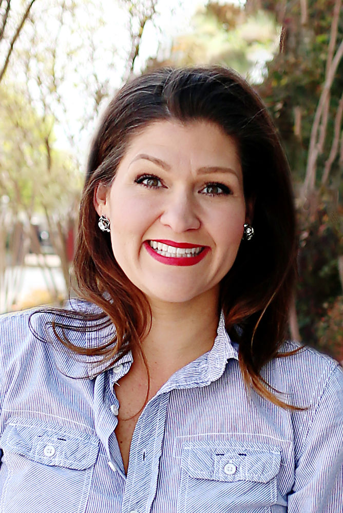 A woman elegantly dressed in a blue shirt, exuding confidence and poise.